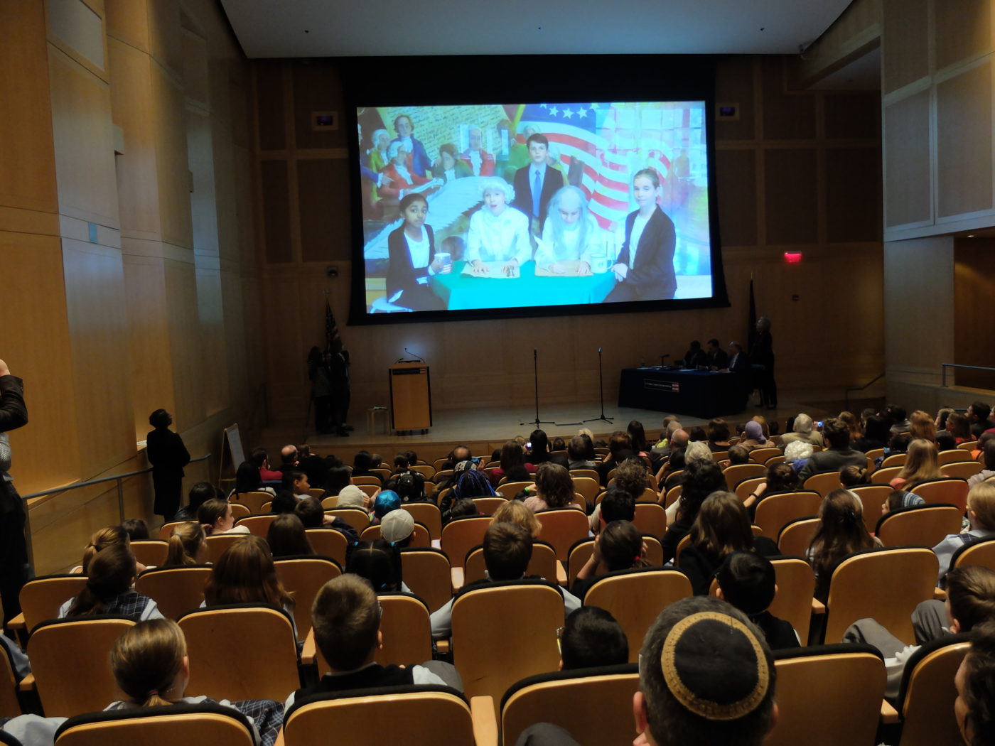 Audience watches a video made by one of the classes.