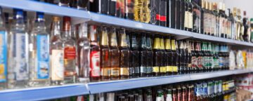 Image of liquor bottle on grocery store shelves.