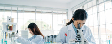 Scientists working in laboratory using microscope