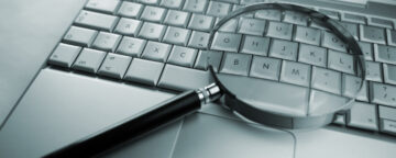 Magnifying glass on computer. Used in story about correcting misinformation.