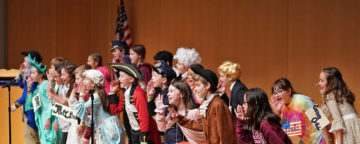 Costumed students from Radnor Elementary perform on stage at the 2018 Citizenship Challenge.