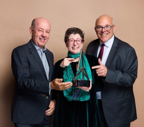 Picture of Tom Yellen, Andrea (Ang) Reidell, and R. Lance Holbert, featuring an Athem Award trophy.