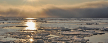 Sun reflected in the icy Arctic Ocean.