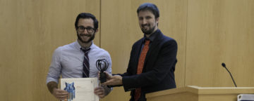 Postdoctoral fellow Matt Motta (left) accepts the Elsevier Atlas award.