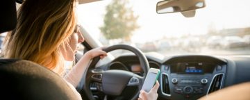 Young driver using cell phone while driving