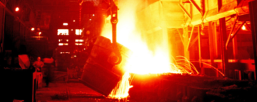 Worker watches steel being poured in factory. Credit: Stuart Rankin.