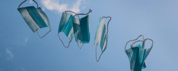 Blue surgical masks floating against a blue sky.