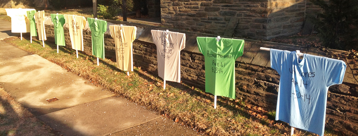 Memorial for victims of gun violence, with T-shirts displaying victims' names, ages, and date of death.