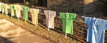 Memorial for victims of gun violence, with T-shirts displaying victims' names, ages, and date of death.